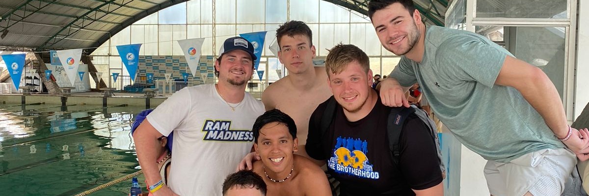 Smilende gruppe VITA Explorers ved en indendørs pool i Córdoba, Argentina, efter en vandaktivitet.