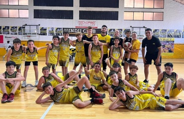 Hold af unge basketballspillere i gule trøjer, der poserer i en sportshal i Córdoba, Argentina, sammen med VITA Explorers.