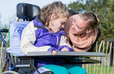 VITA Explorer udveksler et varmt, fortroligt blik med et barn med flere handicap i kørestol