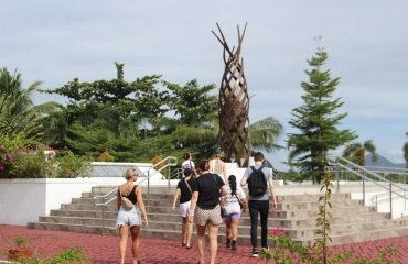 Gruppe af deltagere, der går mod et moderne monument omgivet af tropisk vegetation på Filippinerne